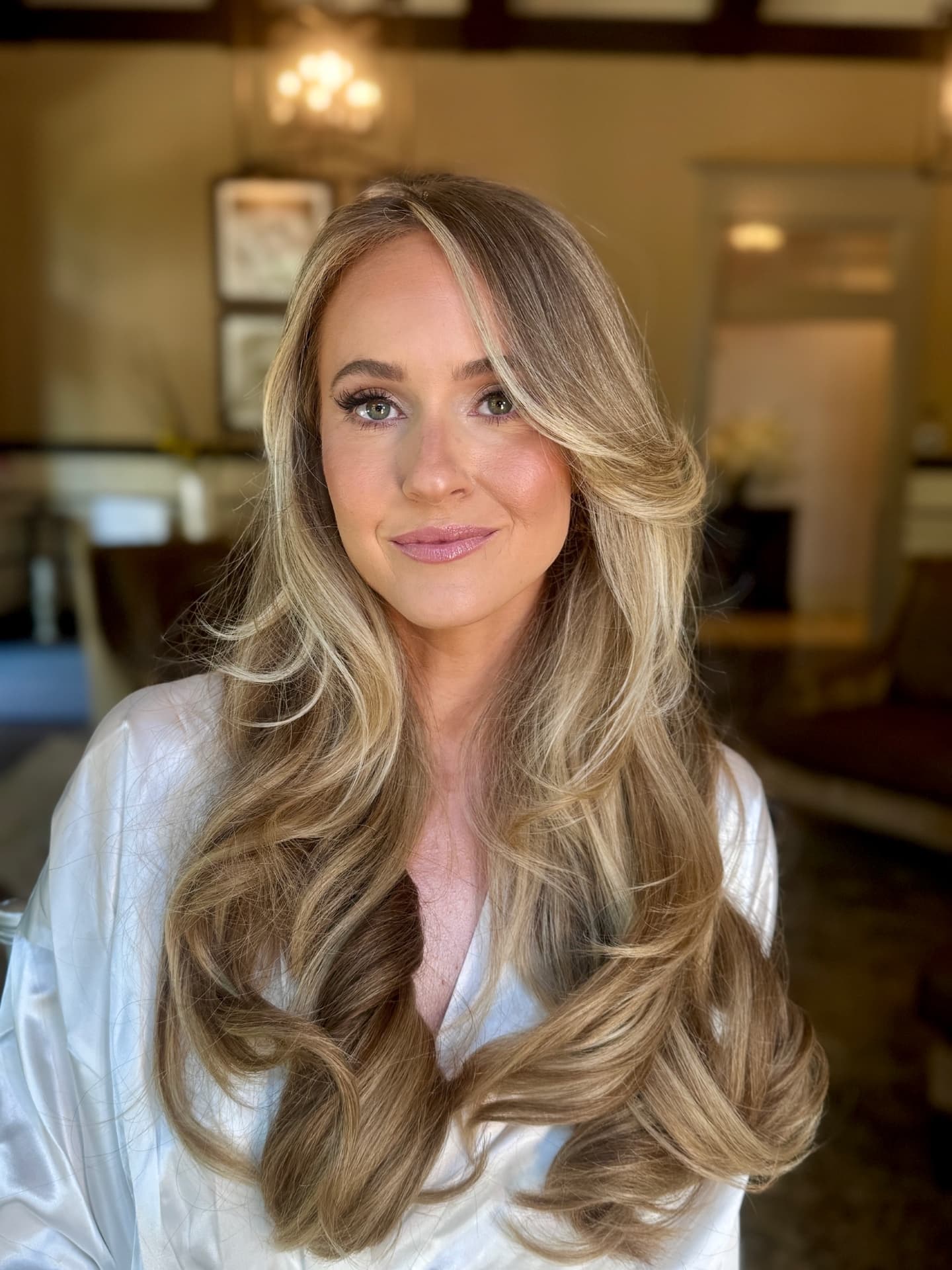 Bride in a silk robe with soft, radiant bridal makeup